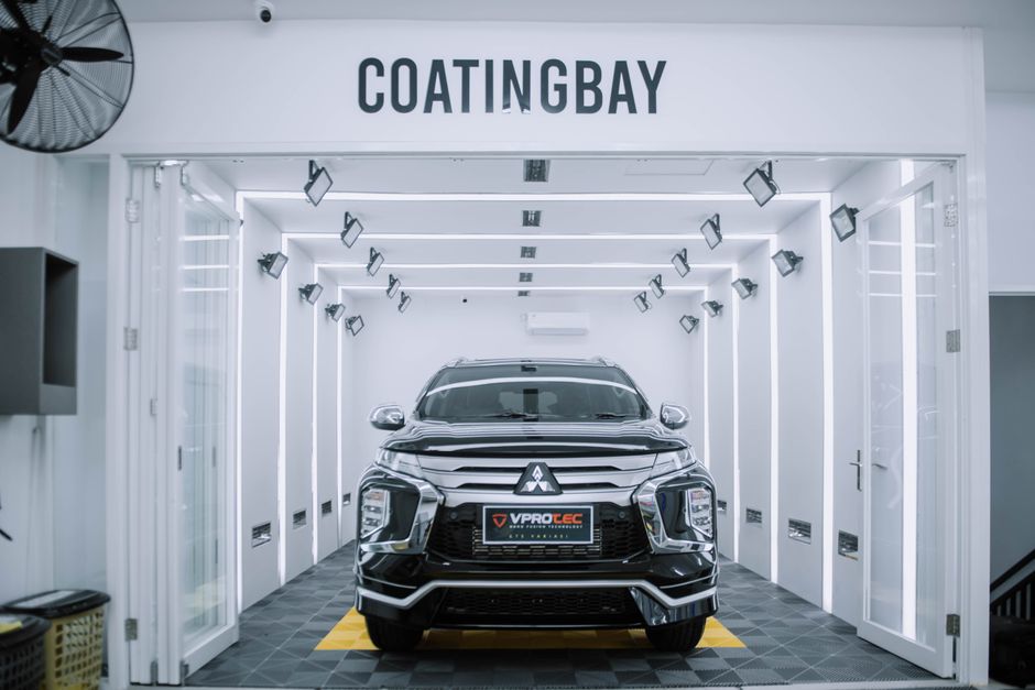 A sleek Mitsubishi SUV inside a modern automotive coating facility.